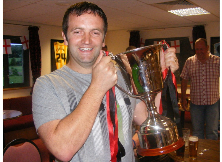 Rutherford manager Dan Hall proudly holds the first division championship trophy