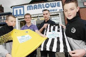 Coach Stephen Hesketh with players Caoimhin McKenna and Ciaran McAuley receiving their new kit from Gareth Burns of sponsor Marlowe Cleaners
