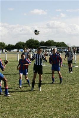 Fryston's player heads clear as Thones players suround him