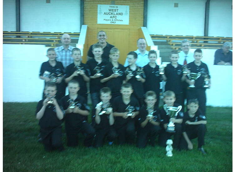 The squad and coaches with their trophies